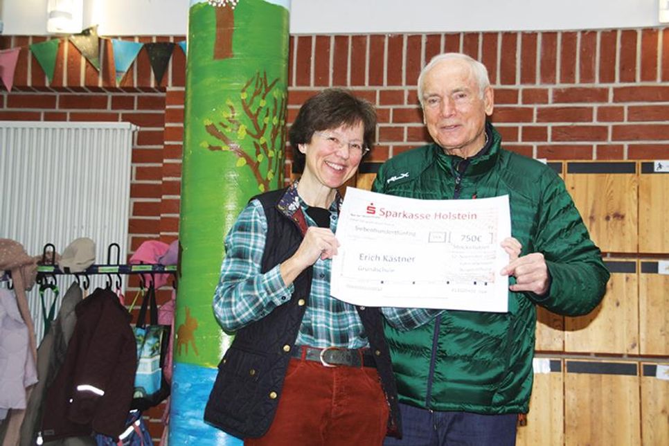 Marion Rehmer, kommissarische Leiterin der Stockelsdorfer Grundschule, und Volker Olbers, Vorsitzender der Bürgerstiftung, päsentieren den Spendenscheck.