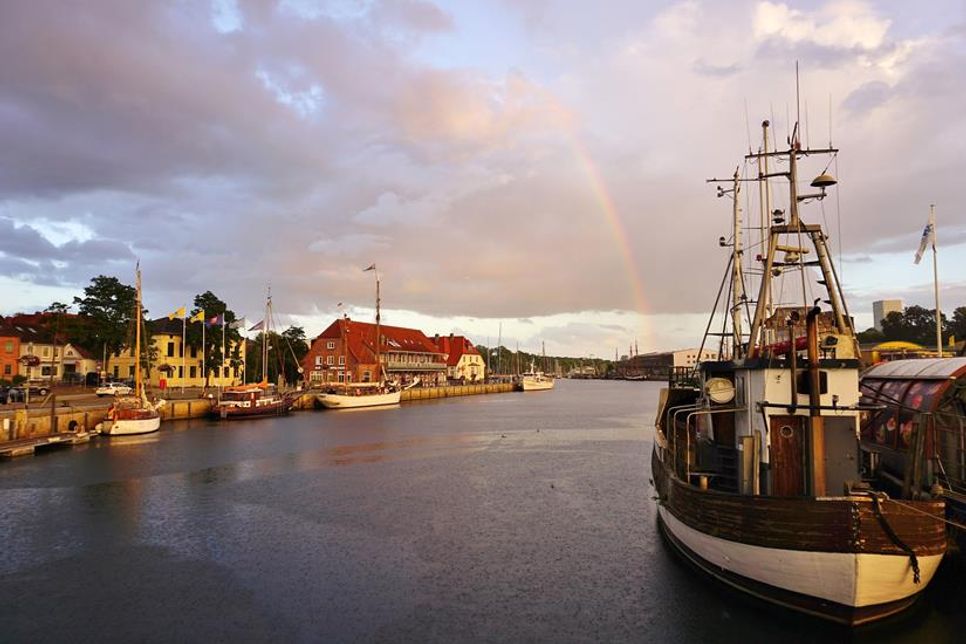 Abends an der Neustädter Hafenbrücke: Klaus Erlwein hat diesen stimmungsvollen Moment festgehalten. Die historischen Schiffe und Gebäude entlang der Hafenkante spiegeln wider, was Neustadt so besonders macht.