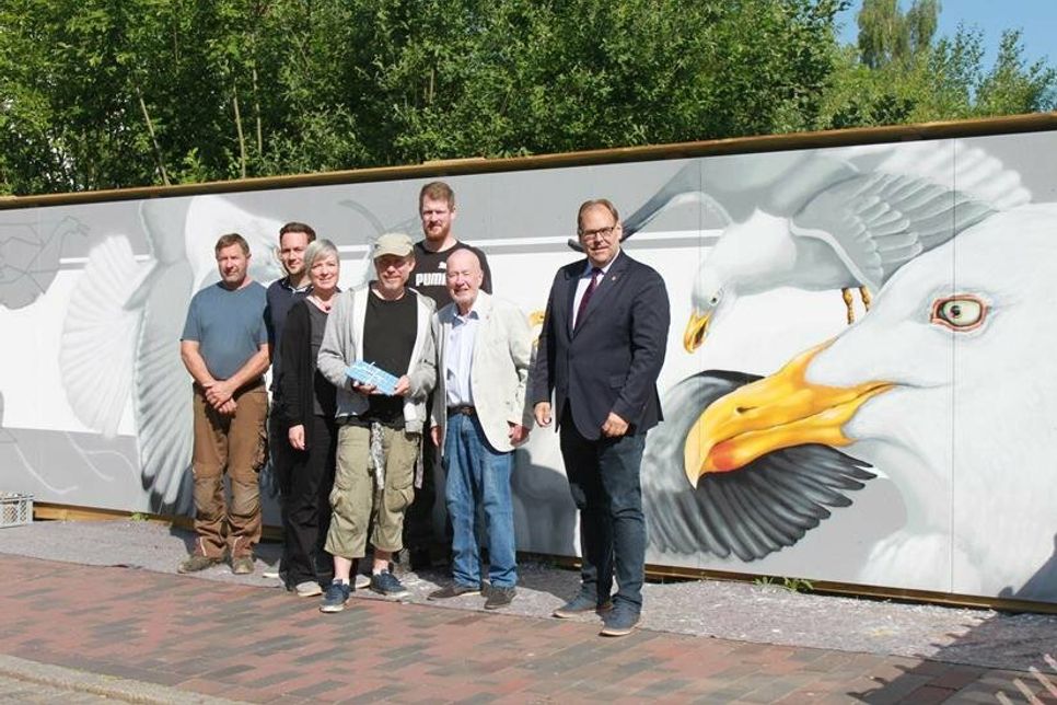 Heike Rhein, Künstler Honsar, Bürgervorsteher Sönke Sela, Bürgermeister Mirko Spieckermann (vorne v. lks.) und die helfenden Hände der Stadt vor dem Kunstwerk in der Brückstraße.