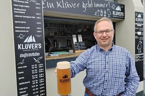 Inhaber Olaf Klüver mit einem frisch gezapften „Klüver‘s“-Bier vor der Hafenräucherei in Niendorf/Ostsee.