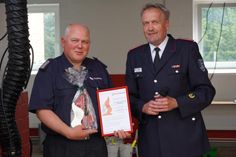 Ortswehrführer Andreas Scharrenberg (lks.) bekam von Lars Wellmann vom Kreisfeuerwehrverband eine Ehrenurkunde zum Jubiläum überreicht.