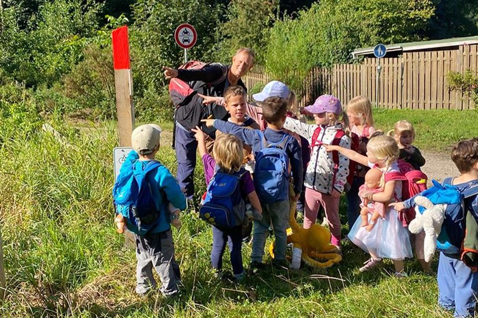 Der Mediziner Michael Damköhler erklärt den Kindern im Pansdorfer Wald die Bedeutung des Notfallbaums an der Mühle.