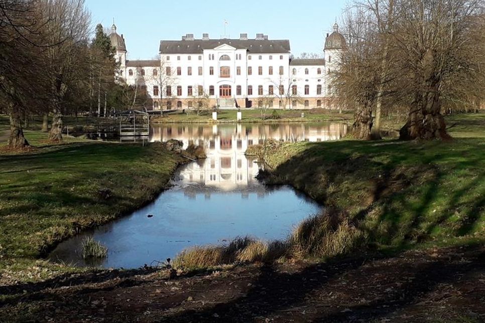 Das Herrenhaus Salzau mit der Spiegelung im Teich.