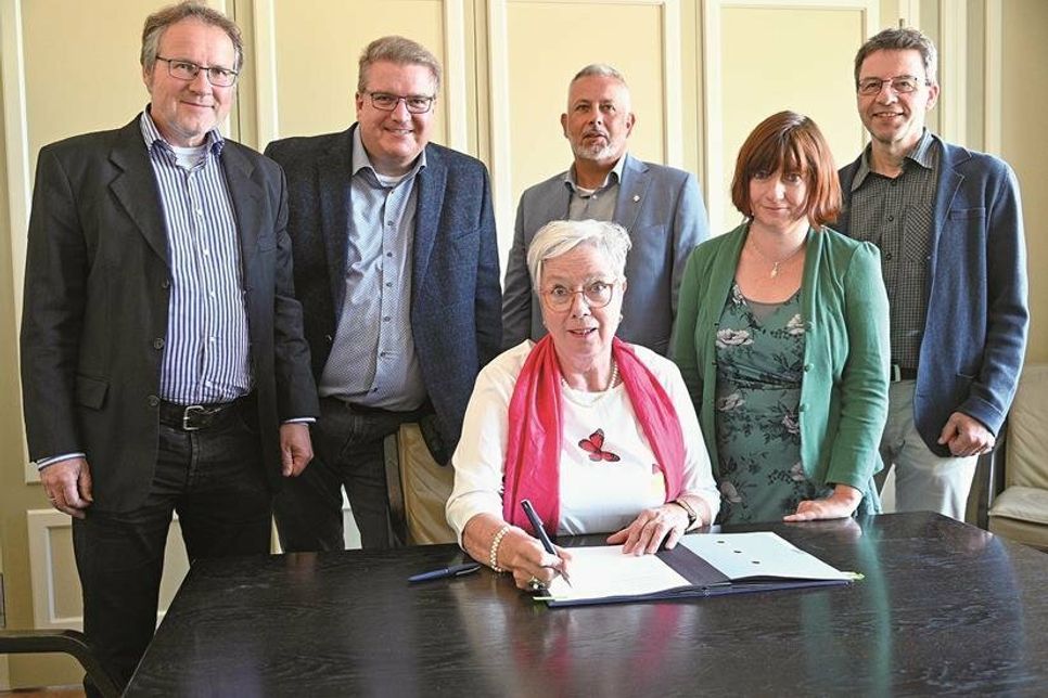 Das Foto (KKOH/Heinen) zeigt v. li. stehend: Pastor Ulf Teichmann (in Vertretung für den KGR-Vorsitzenden Jörn Lauenroth), Propst Dirk Süssenbach, Bürgermeister Jörg Saba, Heike Steinbach und Dr. Gerdt Hübner (Stv. Vors. des Fördervereins). Am Tisch signierend sitzt Beate Rinck, Vorsitzende des Fördervereins.