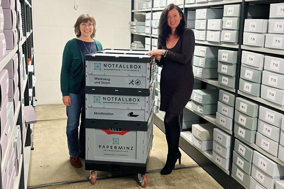 Gemeindearchivarin Andrea Looks (links) und Bürgermeisterin Bettina Schäfer neben der Notfallbox im Gemeindearchiv.