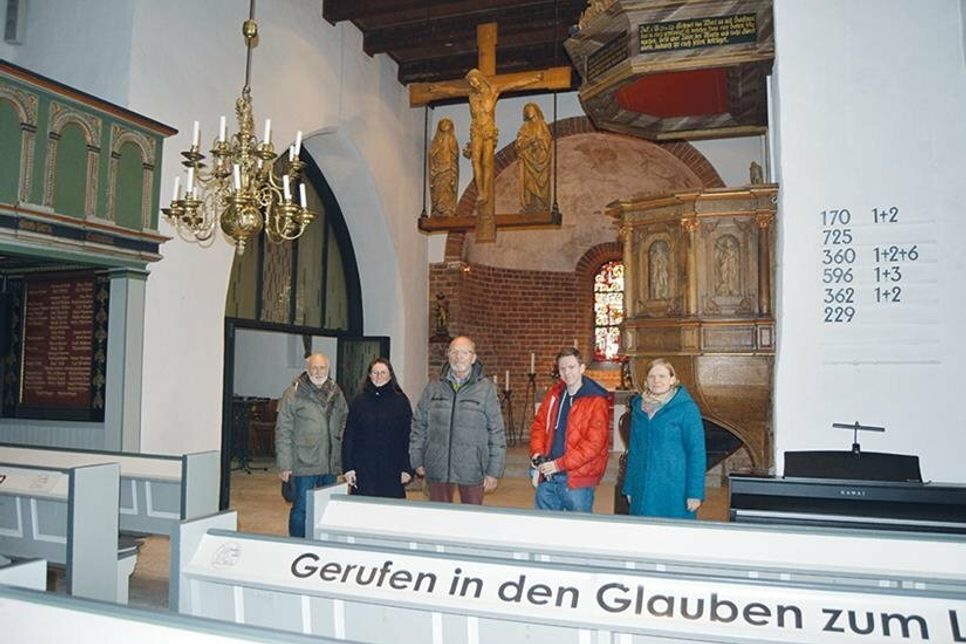 Neben Kreuz und Kronleuchter gibt es 14 weitere Kunstwerke in der Rensefelder Kirche zu sehen, die IT-Experte Felix Zeep (2.v.r.) digital verwaltet.