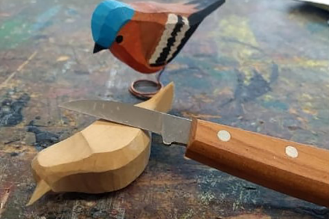 Im Kreativ-Workshop werden Vogelsilhouetten mit Handschnitzmessern bearbeitet.