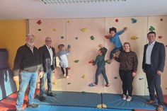 Andreas Kröger, Jens Puschmann, Alkje Kohlsaat und Michael Robien (v. lks.) freuen sich gemeinsam mit den Kindern über die neue Klettermöglichkeit im Turnraum.