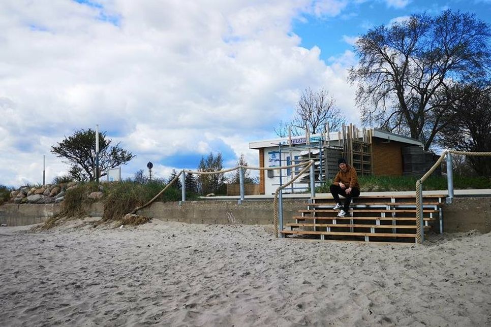 Florian Friedl, Praktikant des Tourismus-Service Ostseebad Kellenhusen, bewundert die neu angebaute Treppe, die den Strand mit der Promenade verbindet.