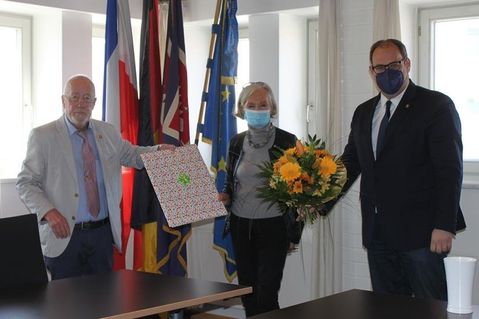 Blumen und eine Collage von Neustadt-Bildern gab es zum Abschied für Gisela Künkel von Bürgervorsteher Sönke Sela und Bürgermeister Mirko Spieckermann (re.).