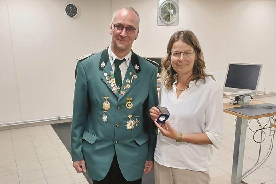 Bad Schwartaus Bürgermeisterin übergibt die Ehrenmedaille der Stadt an den Gilde-Vorsitzenden Niko Schramme.
