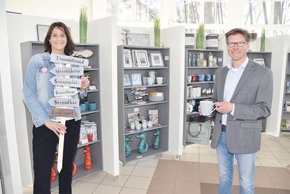 Timmendorfer Strands Tourismuschef Joachim Nitz und Marketingleiterin Silke Szymoniak vor den mobilen Regalen mit neuen Souvenir- und Dekoartikeln.